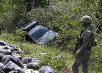 ANGGOTA tentera memeriksa sebuah kenderaan pacuan empat roda jenis Toyota Hilux disyaki membawa muatan daun ketum yang terbabas ketika dikejar pasukan keselamatan itu di Kampung Sungai Kecil, Kuala Nerang. - UTUSAN/SHAHIR NOORDIN