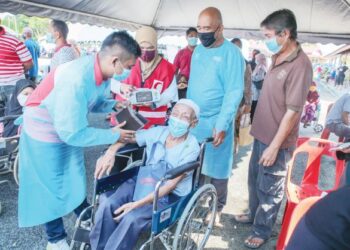 Petugas kesihatan memeriksa tahap kesihatan seorang penerima vaksin, Wahab Ahamad, 96, dalam program Mobilisasi Vaksin Komuniti (MOVAK) di Desa Keda Kampung Bukit, Kedah. – UTUSAN/ SHAHIR NOORDIN