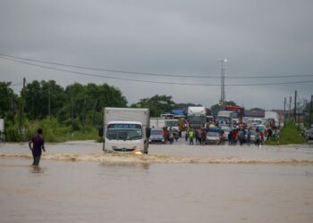 PENGGUNA jalan raya terpaksa meredah air dalam kejadian banjir di Pokok Sena, Kedah. - UTUSAN/ SHAHIR NOORDIN