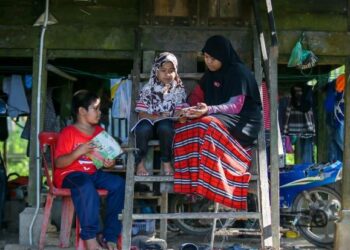 NURAINI Abdun Toleb, 12, (kanan) membantu adiknya, Siti Aisyah, 8, (tengah) dan Aidil Hairi, 11, yang bersekolah di Sekolah Kebangsaan Tengku Abdul Rahman Putra mengikuti modul pengajaran dan pembelajaran di rumah (PdPR) di Kampung Jelutong, Kuala Nerang. - UTUSAN/SHAHIR NOORDIN