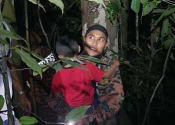 SEORANG anggota bomba membantu menyelamatkan seorang kanak-kanak yang ditemui sesat di kawasan bukit di Kampung Tandop, Baling malam semalam.