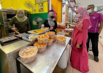FATIMAH Harun (kiri) menyiapkan tempahan baulu viral di premis perniagaan Emanis Baulu Panas di Kompleks Pekan Rabu Alor Setar, Kedah.