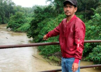 Seorang penduduk  Abdul Wahid Hasan menunjukkan air Sungai Chepir yang keruh di Kampung Padang Toi, semalam