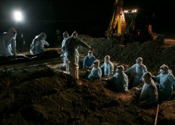 PETUGAS kesihatan yang lengkap berpakaian peralatan perlindungan diri (PPE) menguruskan pengebumian 12 jenazah pesakit COVID-19 dari Hospital Tengku Ampuan Rahimah Klang di Tanah Perkuburan Islam Seksyen 21 Shah Alam, Selangor. - UTUSAN / ZULFADHLI ZAKI