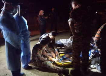 ANGGOTA bomba membawa turun lelaki yang mengalami kekejangan kaki di puncak Bukit Ungku Busu, Lumut, Peraj.  - IHSAN JBPM