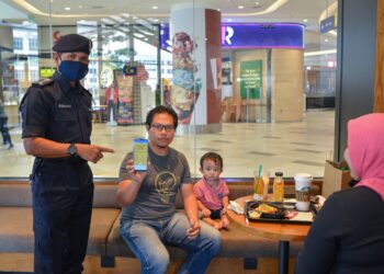 ROHAIMI Md. Isa (kiri) memeriksa sijil digital vaksinasi milik seorang pelanggan yang menikmati hidangan secara dine-in di premis di pusat beli-belah, Kuala Terengganu City Centre (KTCC) di Kuala Terengganu. - UTUSAN/PUQTRA HAIRRY ROSLI