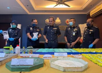 MOHD. RADZI AHMAD (tengah) meneliti acuan simen yang digunakan untuk menyembunyikan syabu yang dirampas daripada saru sindiket pengedaran dadah dalam sidang akhbar di IPD SPU, Butterworth, Pulau Pinang. - UTUSAN/SITI NUR MAS ERAH AMRAN