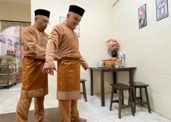 PASANGAN kembar seiras, Mohd. Hilmi Mahmud, 35, dan adiknya, Mohd. Zaidi meraikan Aidilfitri dengan cara tersendiri selepas tidak dapat pulang ke Kedah untuk menziarahi pusara ibu dan ayah mereka. - UTUSAN/NOOR HASLIZA NUSI