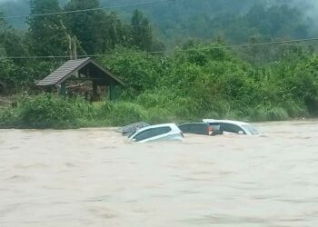 SEBAHAGIAN daripada kereta yang terperangkap dan hampir tenggelam dalam kejadian kepala air di Lata Ulu Kasar, Sungai Tong, Setiu, Terengganu, semalam.