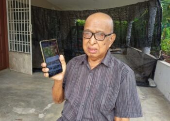 JAZAM Lusah menunjukkan gambar kekejaman komunis semasa darurat yang disimpan di dalam telefon bimbitnya di Felda Ulu Jempol, Maran, Pahang. - UTUSAN/SALEHUDIN MAT RASAD