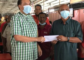 HUSAM Musa menyerahkan sumbangan wang tunai kepada pemandu kereta sewa di Lembah Sireh, Kota Bharu,Kelantan, hari ini. - UTUSAN/ROSLIZA MOHAMED