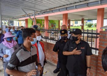 RONALD Kiandee (kanan) berbual dengan pekerja kebun sayur yang menerima vaksin Covid-19 pada program AiVAC di Dewan Serbaguna Kampung Raja di Cameron Highlands  hari ini. - UTUSAN/MOHAMAD HAFIZI MOHD. SAID