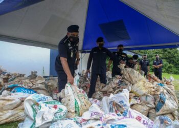MOHD. Taufik Maidin (kiri) menunjukkan sebahagian daun dan air ketum yang akan dilupuskan di IPD Padang Terap, Kedah,  hari ini. - UTUSAN/SHAHIR NOORDIN
