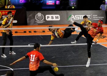 AIDIL Aiman Azmawi (kiri) berusaha menghalang libasan yang dilakukan oleh apit kanan, Azlan Alias pada aksi Liga Premier Emas Anuar Sepak Takraw (STL) 2021/22 di Kompleks Sukan Panji, Kota Bharu, Kelantan, sebentar tadi. - UTUSAN/ZULHANIFA SIDEK