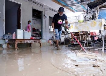PENDUDUK membersihkan rumah yang dilanda banjir lumpur di Kampung Lembah Jaya Ampang. - UTUSAN/FAUZI BAHARUDIN