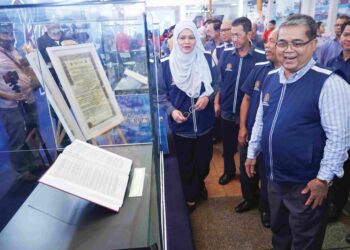 DATUK Aaron Ago Dagang (kanan) diiringi Ketua Setiausaha Kementerian Perpaduan Negara, Datuk Noridah Abdul Rahim melihat dokumen Perjanjian Persekutuan Tanah Melayu yang dipamerkan sempena pelancaran Program Kembara Perpaduan Malaysia Madani di Dataran Muzium Negara Kuala Lumpur. 
– UTUSAN/FAUZI BAHARUDIN