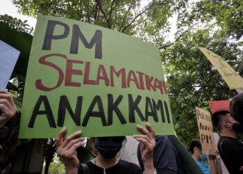 ANTARA keluarga kepada mangsa pemerdagangan manusia rakyat Malaysia yang ditahan dan diseksa oleh sindiket di Kemboja, Laos dan Myanmar memegang plakad sebagai tanda merayu dan memohon campur tangan kerajaan di Pejabat Perdana Menteri, Putrajaya. - UTUSAN/FAIZ ALIF AHMAD ZUBIR