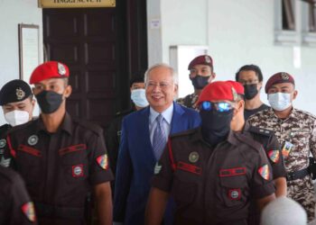 NAJIB Tun Razak diiringi pegawai penjara ketika hadir pada perbicaraan kes rasuah 1MDB di Kompleks Mahkamah Kuala Lumpur. - UTUSAN/SADDAM YUSOFF