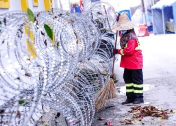 SEORANG pekerja Alam Flora membersihkan sampah di Kampung Segambut Dalam yang dikenakan Perintah Kawalan Pergerakan Diperketatkan (PKPD). - UTUSAN/FAIZ ALIF AHMAD ZUBIR