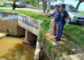 AB. RAHMAN Tambi Adam (tiga dari kiri) menunjukkan ruang sempit untuk aliran air keluar menyebabkan sawah di Paya Luboh, Melaka ditenggelami air setiap kali berlaku hujan lebat. - UTUSAN/AMRAN MULUP