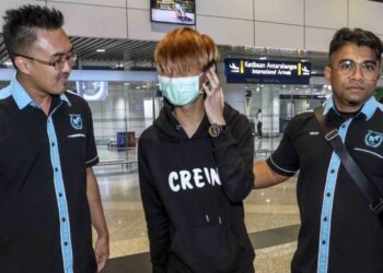 HISHAMUDDIN Hashim (kanan) menyambut ketibaan seorang lelaki Cina berumur 21 tahun (tengah) selepas diselamatkan dari KK Garden Myanmar yang menjadi mangsa pemerdagangan manusia di Balai Ketibaan KLIA. - FOTO/FAISOL MUSTAFA