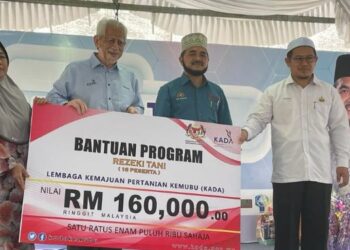 KAMARUDIN Md. Nor (dua dari kiri) menyampaikan replika cek kepada wakil petani sambil disaksikan oleh Nik Muhammad Zawawi (dua dari kanan) di Pasir Puteh, Kelantan, hari ini. FOTO/TOREK SULONG