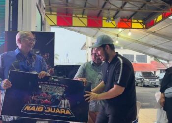ANNUAR Musa (kiri) menyampaikan hadiah kepada pemenang pada Karnival Komuniti Esports Keluarga Malaysia @Ketereh di Kompleks Yayasan Kemiskinan Kelantan (YKK), Melor, Kelantan, hari ini. - FOTO/ROSMIZAN RESDI