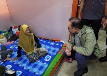 ANWAR Ibrahim (kanan) sempat bertanya khabar dengan warga emas yang turut ditempatkan di PPS SMK Tengku Panglima Raja, Pasir Mas, Kelantan. - FOTO/MUSTAQIM MOHAMED
