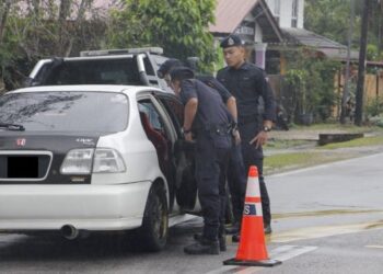 ANGGOTA polis memeriksa kereta yang dinaiki suspek selepas ditahan menerusi Op Selamat di Machang, Kelantan. - FOTO/IHSAN POLIS