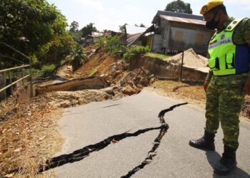 ANGGOTA Jabatan Sukarelawan Malaysia mengawasi keadaan runtuhan tebing dan jalan di Kampung Jalan Pohon Celagi, Pasir Mas, Kelantan. - FOTO/ZULHANIFA SIDEK