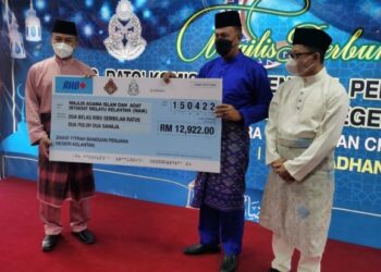 PENYERAHAN replika cek zakat fitrah banduan diwakili Nordin Muhamad (tengah) kepada Ameer Azeezy Tuan Abdullah sambil diperhatikan Mat Yaacob (kanan) di Penjara Pengkalan Chepa, Kota Bharu semalam. - FOTO/ROSALWANI CHE SOH