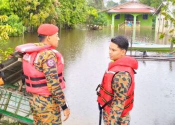 AHMAD Nazarudin Mat Husin (kiri) meninjau paras air banjir di Kampung Tersang, Rantau Panjang, Kelantan, hari ini. - FOTO/ROHANA ISMAIL