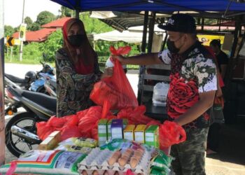 GENG Basmi Lapar diketuai Mohamed Rafiez mengagihkan bekalan makanan kepada penerima di kediamannya di Telipot, Kota Bharu. - UTUSAN/ROSLIZA MOHAMED