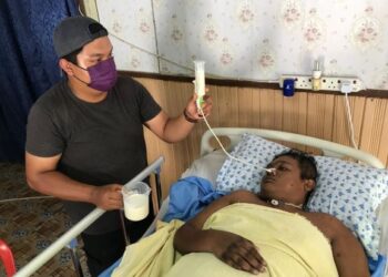 RAJA Mohd. Iskandar Raja Ibrahim memberi susu kepada abangnya, Raja Azlan yang terlantar sakit di Kampung Star Baru, Gua Musang, Kelantan. – UTUSAN/AIMUNI TUAN LAH
