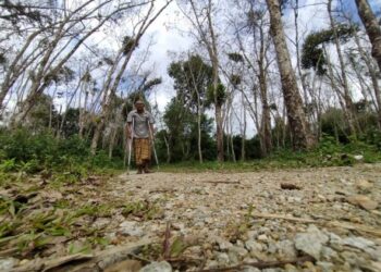 IDRIS Jusoh menunjukkan jalan di Kampung Perol Lubok Tegayong, Pasir Mas yang ditabur batu oleh penduduk kerana masih tidak diturap selepas 30 tahun mereka menunggu. - FOTO/YATIMIN ABDULLAH