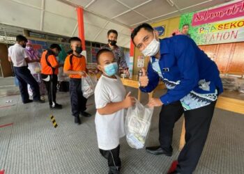 SEBAHAGIAN murid asnaf dan anak yatim ceria menerima lauk-pauk pemberian guru mereka di SK Bukit Jawa, Pasir Puteh, Kelantan. - FOTO/TOREK SULONG