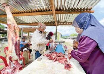 ABDULLAH Ismail (bersemutar) melayan pembeli di gerai daging lembu yang dibuka di tepi jalan Kampung Laloh, Kuala Krai. - FOTO/TOREK SULONG