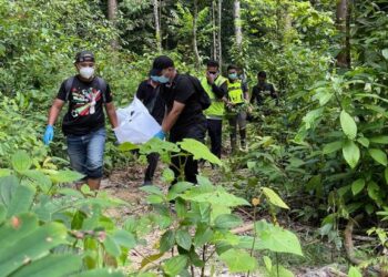 ANGGOTA polis membawa keluar mayat reput dari kawasan hutan Lata Cheng, Machang, Kelantan petang ini. - UTUSAN/TOREK SULONG