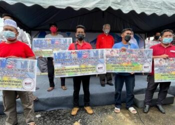 KAMARUDIN Md. Nor (belakang, tengah) bersama sebahagian penerima bantuan Program Transformasi Sosio Ekonomi Hasil Tani Keluarga Malaysia anjuran KADA di Pasir Puteh, Kelantan, hari ini. - FOTO/TOREK SULONG