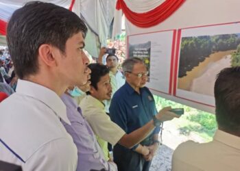 MUSTAPA Mohamed (kanan) mendengar taklimat disampaikan berhubung pembinaan Jambatan Sungai Nibong, Kuala Balah di Jeli, Kelantan, hari ini. - FOTO/ROSALWANI CHE SOH