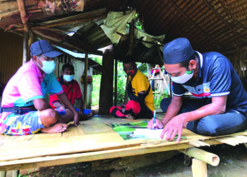 PENDUDUK Orang Asli Bateq mengisi borang pendaftaran vaksin di Kampung Aring 5 di Gua Musang, Kelantan, semalam. - UTUSAN/AIMUNI TUAN LAH