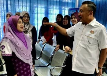 RUSLIN Jusoh (kanan) beramah mesra dengan kakitangannya yang terjejas banjir di Pejabat JPN, Tumpat Kelantan hari ini. - FOTO/ROSLIZA MOHAMED