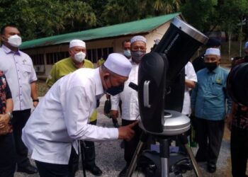 AHMAD Yakob melihat alat cerapan anak bulan ketika Majlis Perasmian Sambutan Hari Hutan Antarabangsa Peringkat Negeri Kelantan di Taman Eko Rimba Bukit Bakar, Machang. - FOTO/ROHANA MOHD. NAWI