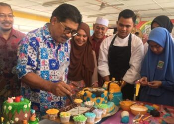 MD. Alwi Che Ahmad (kiri) turut mengambil peluang membuat hiasan kek ketika melawat pameran pada Program Jelajah Pendidikan Luar Bandar Peringkat Negeri Kelantan 2022 di SMK Kok Lanas, Kelantan, hari ini. - FOTO/ROSMIZAN RESDI