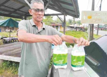 ARIFFIN Awang Chik menunjukkan gula yang dibeli dari Thailand di Kampung Derdap, Tumpat, Kelantan. 
– UTUSAN/ROHANA ISMAIL