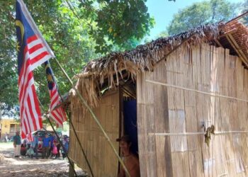 ZAKARIA Abdullah mengibar Jalur Gemilang di rumahnya di Kampung Pasir Linggi, Pos Lebir, Gua Musang, Kelantan. – UTUSAN/AIMUNI TUAN LAH