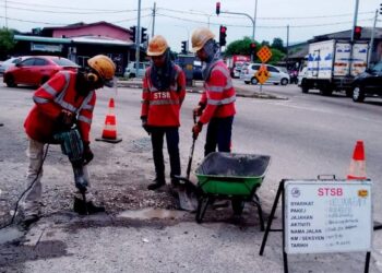 KERJA-kerja menurap jalan yang berlubang giat dilakukan bagi mengelakkan pengguna berdepan bahaya di Cabang Empat Guchil Bayam, Kota Bharu, Kelantan semalam. – UTUSAN/ROHANA MOHD. NAWI
