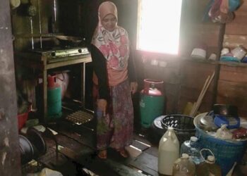 CHE Esah Yusoff menunjukkan keadaan lantai rumahnya yang reput di Kampung Dusun Durian, Dabong,
Kuala Krai, Kelantan.
– FOTO/ROSMIZAN RESDI