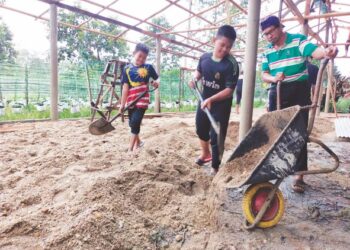 PENDUDUK bergotong-royong menyiapkan tempat untuk berlindung semasa banjir di Kampung Tasek Bakong, Rantau Panjang, Kelantan. 
– UTUSAN/YATIMIN ABDULLAH