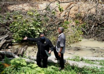 MUHAMMAD Arafat Varisai Muhammad (kanan) bersama Abdul Aziz Abdul Manaf menunjukkan pencemaran sungai berpunca aktiviti perlombongan kaolin di Kampung Kolam, Tanjung Rambutan di Ipoh, Perak, hari ini. - FOTO/ZULFACHRI ZULKIFLI